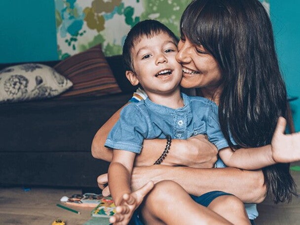 Happy women kissing son in her lap Happy women kissing son in her lap