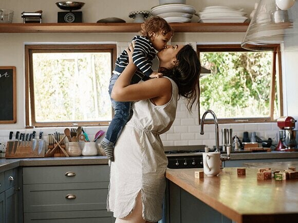 Mother lifting her baby and kissing