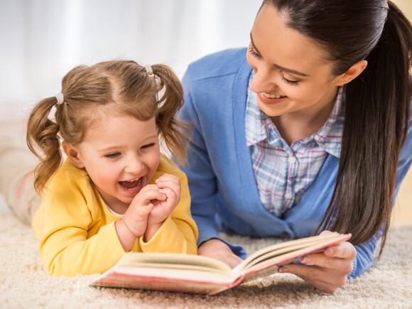 Mother and baby girl reading book