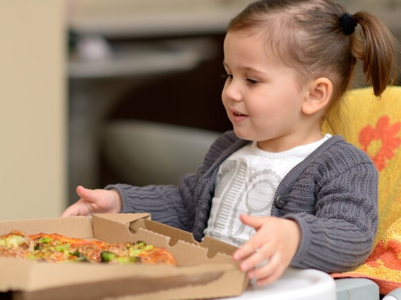 Baby girl eating pizza