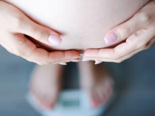 pregnant woman on weighing machine