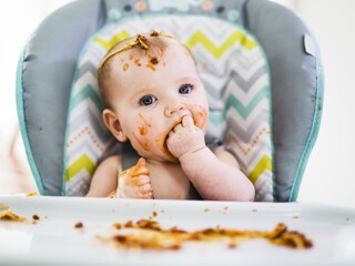 Messy baby eating food