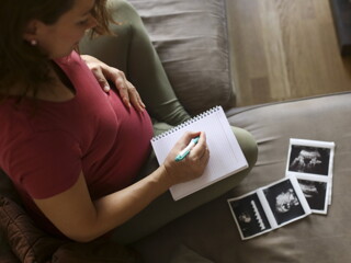 Pregnant woman writing in a book