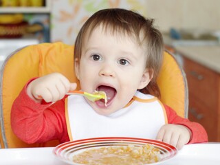 Baby eating food with a spoon