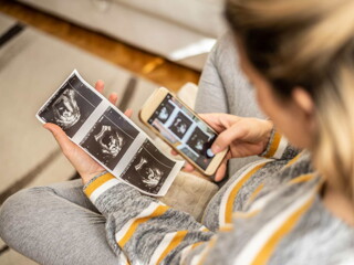 pregnant lady taking photo of scanning report