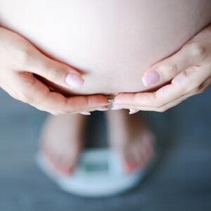 pregnant woman on weighing machine