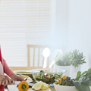 Pregnant woman cutting vegetable