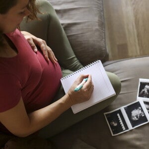 Pregnant woman writing in a book