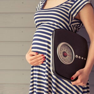 Pregnant woman with weighing machine