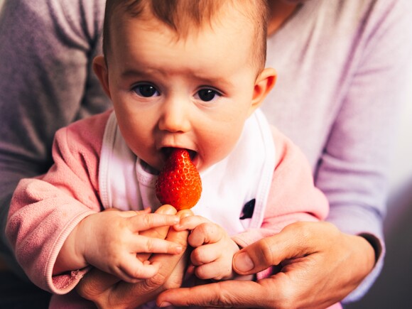 baby eating strawberry