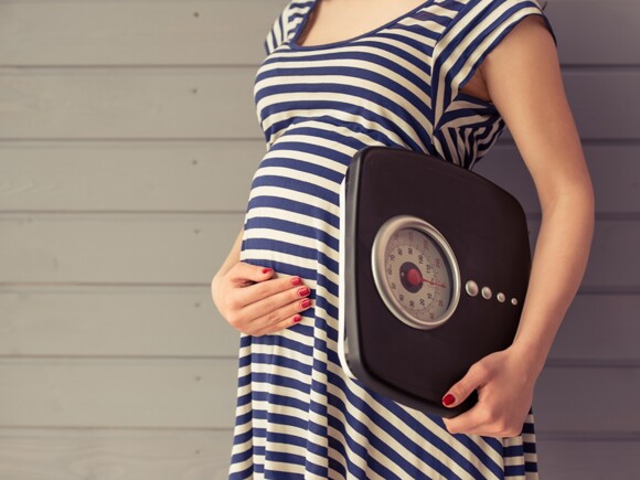 Pregnant woman with weighing machine